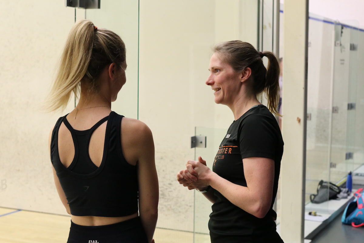 Players rallying with their coach during a racketball coaching session